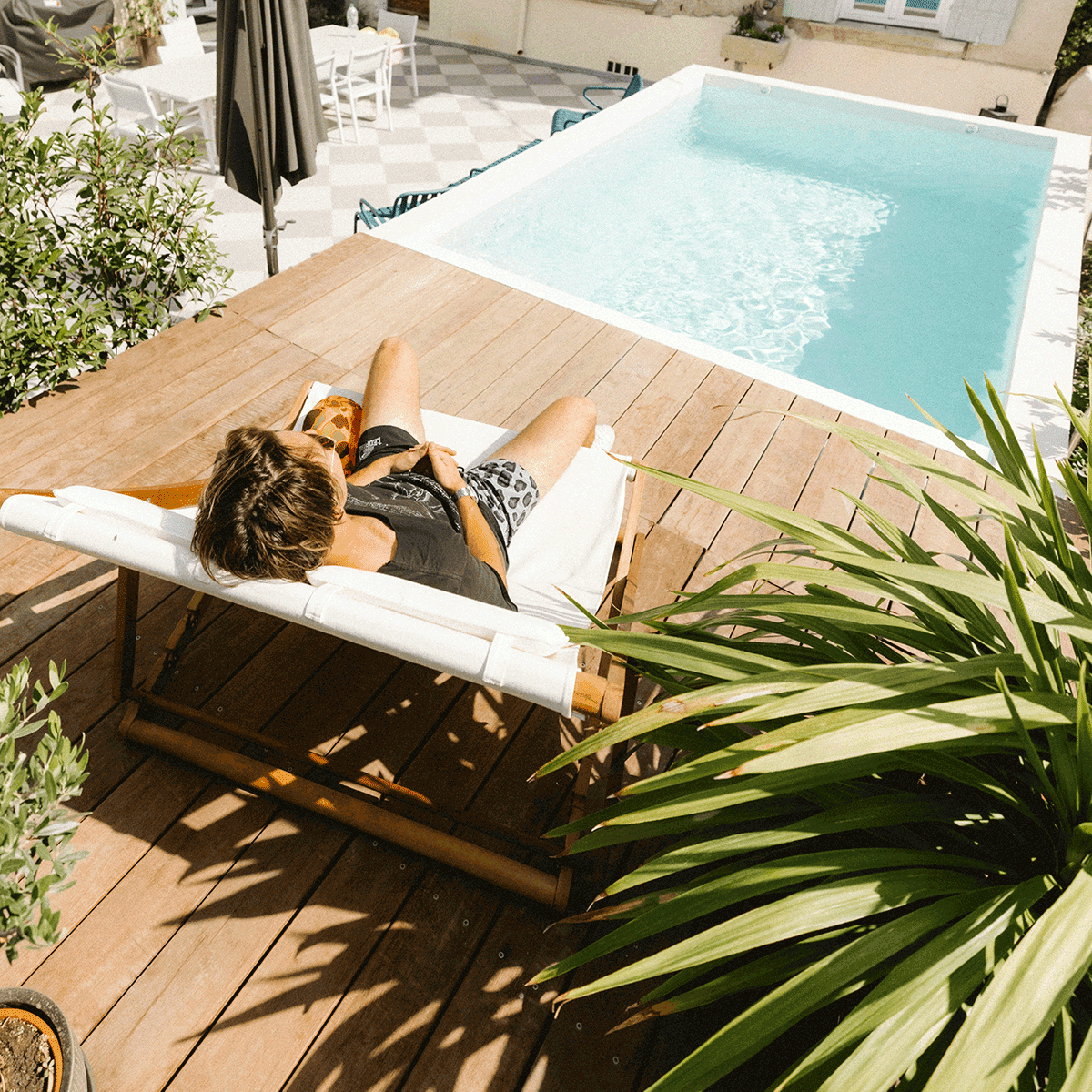 Client sur la terrasse de sa piscine en container satisfait de la société Piscine Cargo